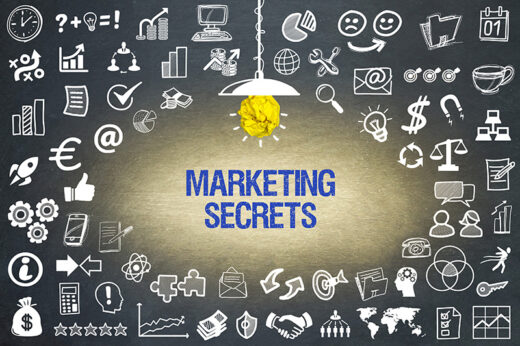 Blaue Schrift "Marketing Secrets" von einer einzelnen Hängelampe beleuchtet, rund herum auf dunklem Hintergrund verschiedene weiße Icons für Content-Kampagnen